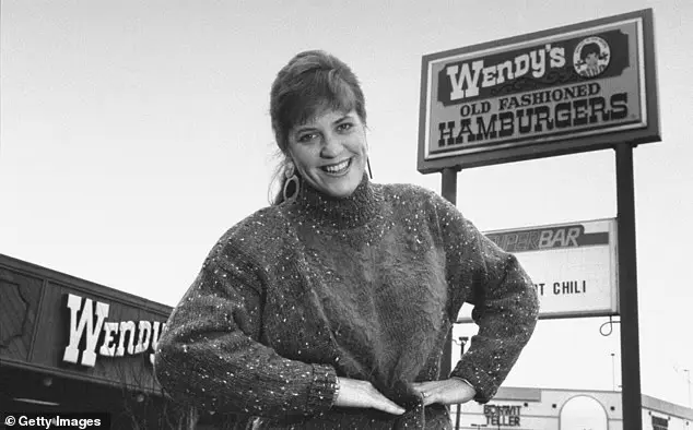 Wendy Thomas Morse posando frente a un restaurante Wendy’s con el icónico letrero de la cadena en 1989